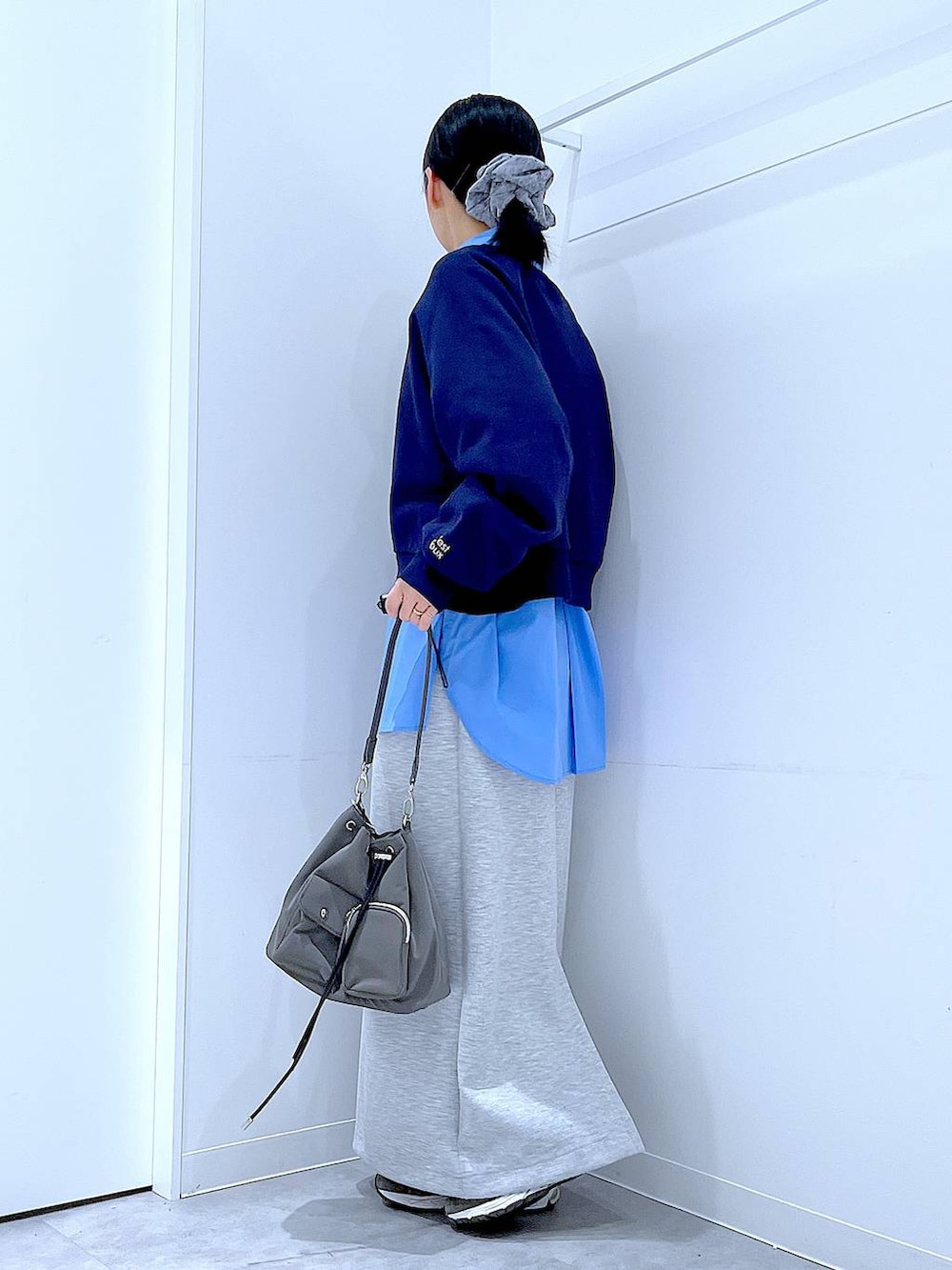 グレー系のショルダーバッグ、グレー系のスカート、ブルー系のシャツ/ブラウスを着用したレディースの春コーディネートの3枚目の写真