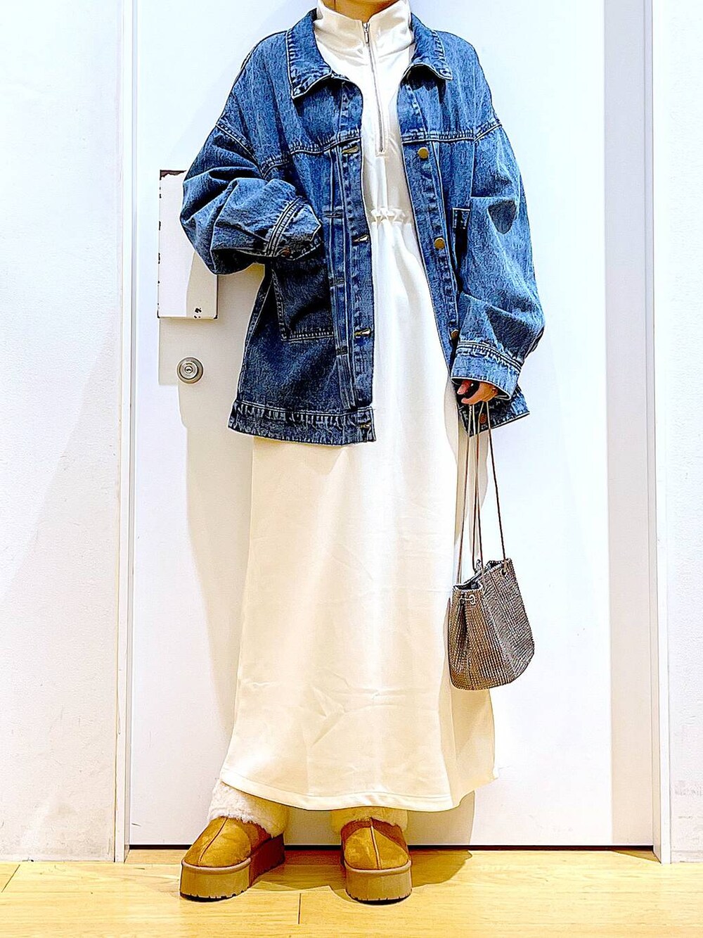 グレー系のショルダーバッグ、ベージュ系のワンピース、ベージュ系のスリッポンを着用したレディースの秋コーディネートの6枚目の写真