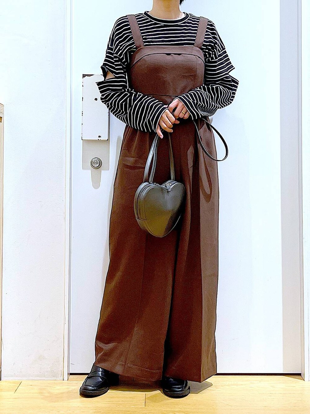シルバー系のショルダーバッグ、ブラック系のローファー、ブラウン系のサロペット/オーバーオールを着用したレディースの秋コーディネートの6枚目の写真