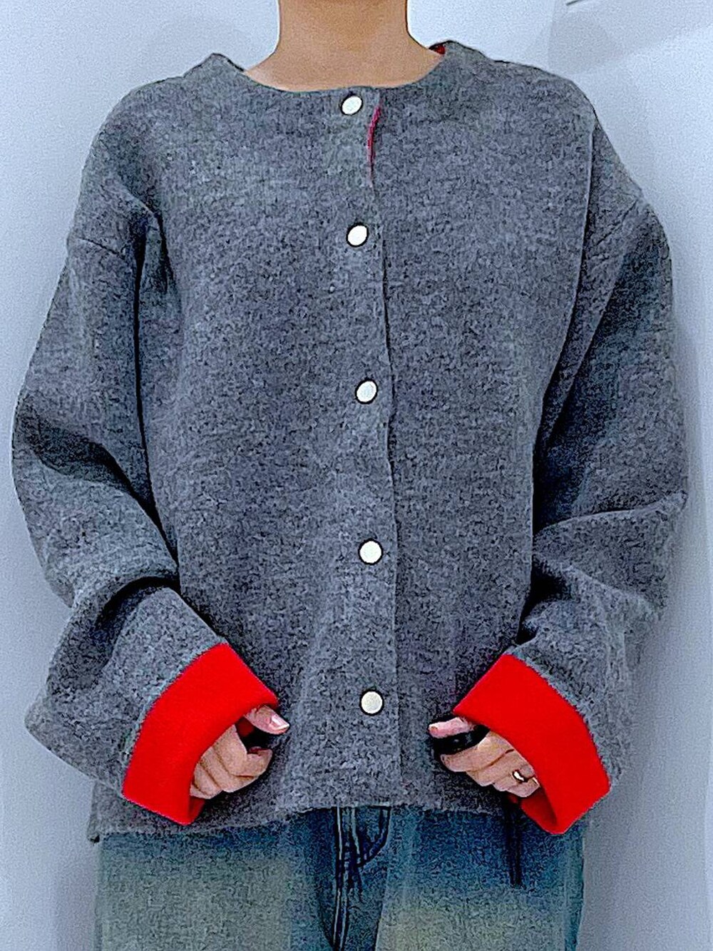 ブルー系のデニムパンツ、ブラック系のブーツ、ホワイト系のショルダーバッグを着用したレディースの冬コーディネートの7枚目の写真