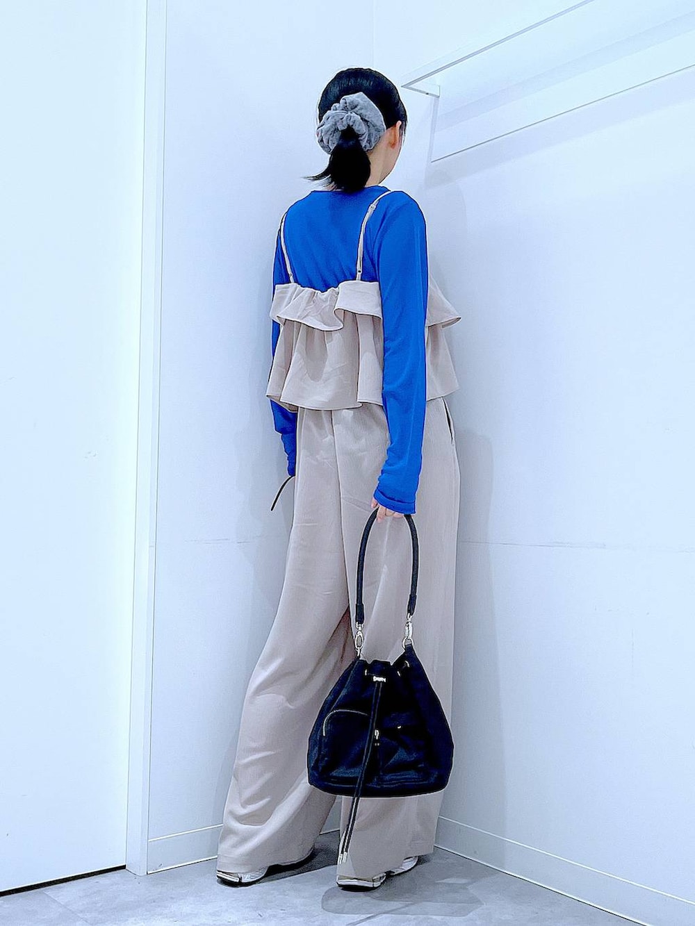 ベージュ系のサロペット/オーバーオール、ブラック系のショルダーバッグ、グレー系のシュシュを着用したレディースの春コーディネートの5枚目の写真