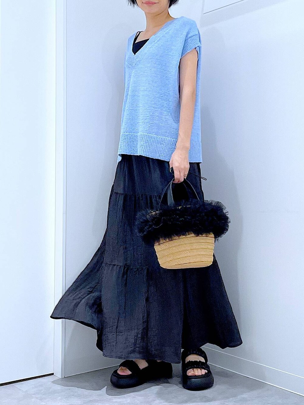 ベージュ系のショルダーバッグ、ブラック系のサンダル、ブルー系のベストを着用したレディースの夏コーディネートの6枚目の写真