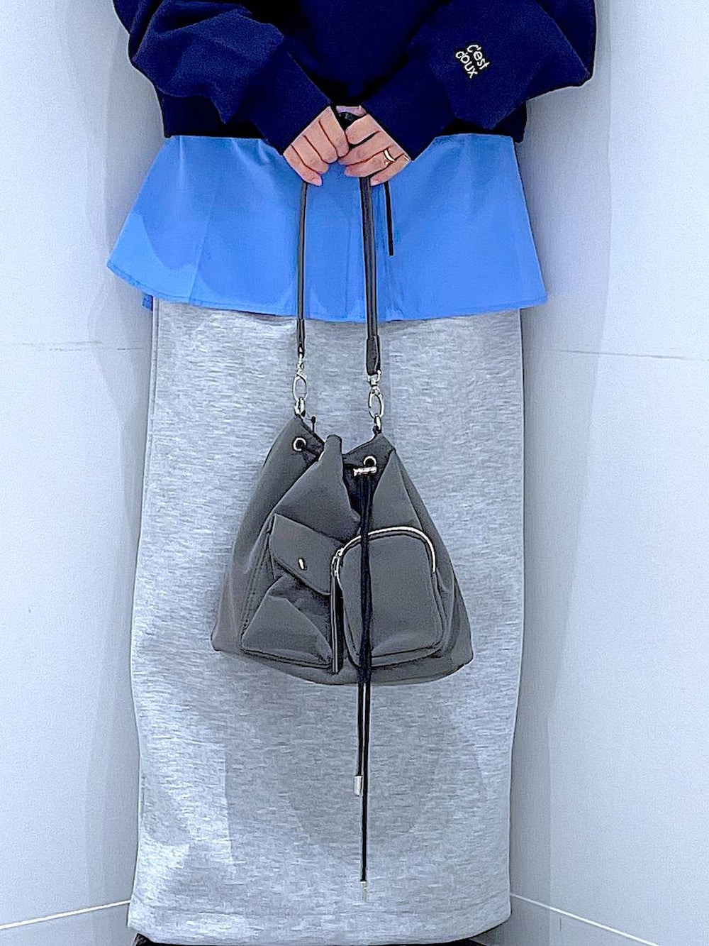 グレー系のショルダーバッグ、グレー系のスカート、ブルー系のシャツ/ブラウスを着用したレディースの春コーディネートの9枚目の写真