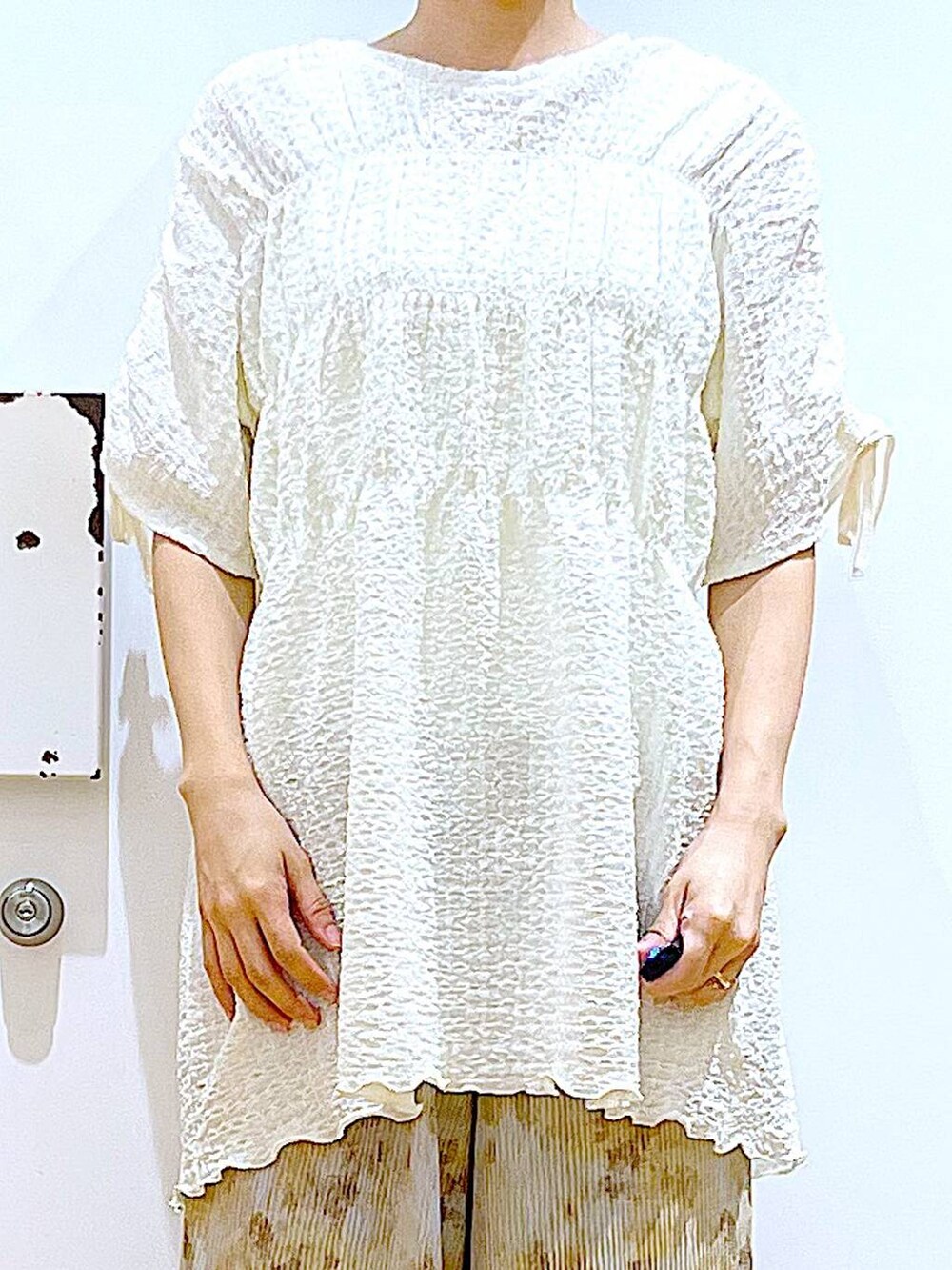 シルバー系のパンプス、ホワイト系のショルダーバッグ、ベージュ系のその他パンツを着用したレディースの春コーディネートの7枚目の写真