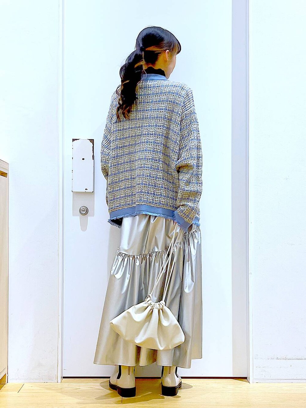 ブラック系のTシャツ/カットソー、シルバー系のスカート、ブルー系のカーディガン/ボレロを着用したレディースの冬コーディネートの5枚目の写真