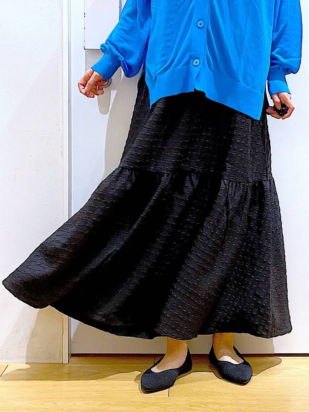 シルバー系のショルダーバッグ、ブラック系のワンピース、ブラック系のパンプスを着用したレディースの春コーディネートの8枚目の写真