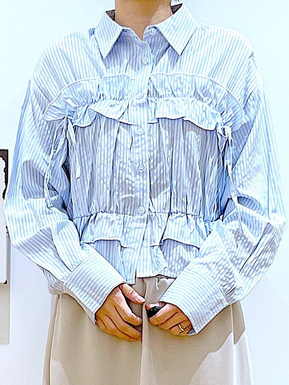 ブルー系のショルダーバッグ、ホワイト系のパンプス、ベージュ系のスカートを着用したレディースの春コーディネートの7枚目の写真