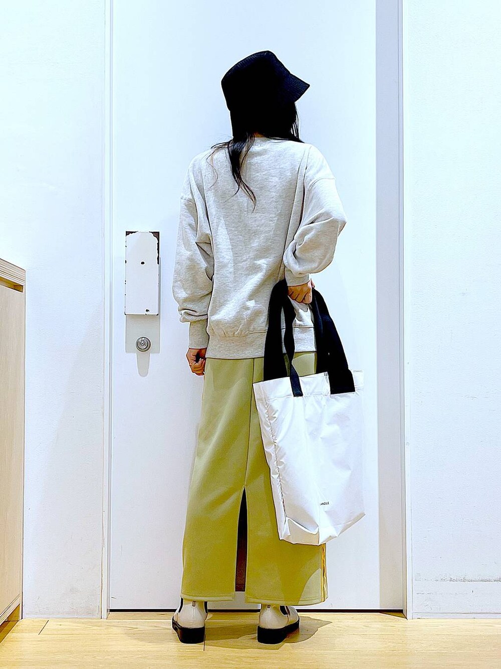 ベージュ系のスウェット、ベージュ系のブーツ、ホワイト系のトートバッグを着用したレディースの冬コーディネートの5枚目の写真