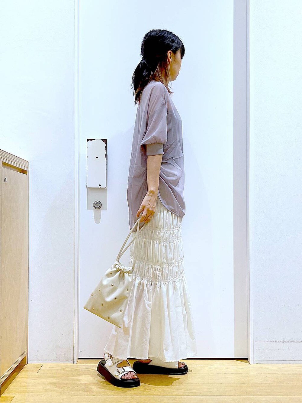 ホワイト系のサンダル、ホワイト系のショルダーバッグ、ホワイト系のスカートを着用したレディースの夏コーディネートの4枚目の写真