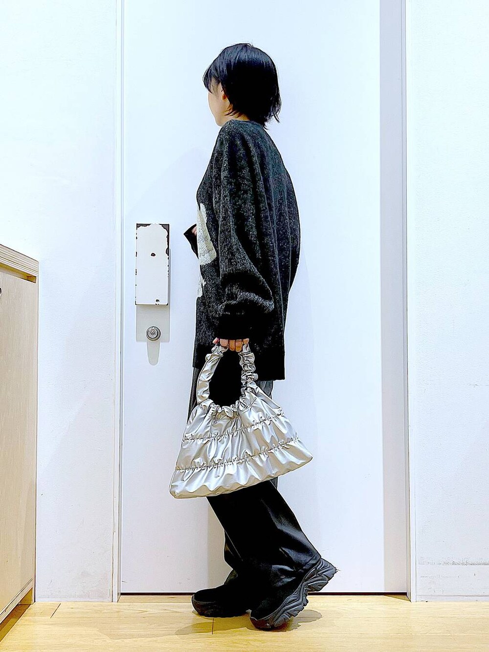 ブラック系のブーツ、ブラック系のその他パンツ、シルバー系のショルダーバッグを着用したレディースの冬コーディネートの3枚目の写真