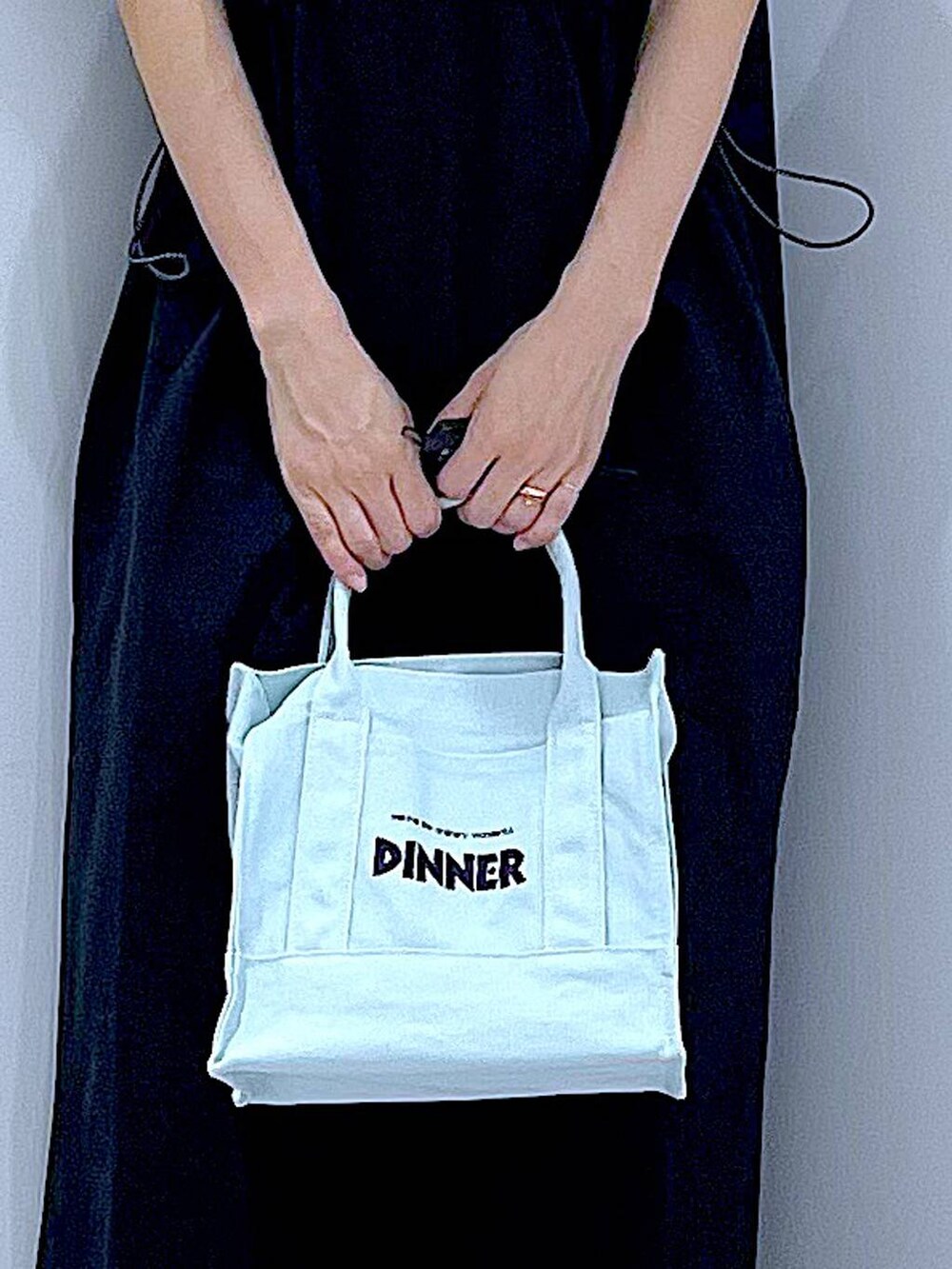 ブラック系のサンダル、ブラック系のワンピース、グリーン系のトートバッグを着用したレディースの夏コーディネートの9枚目の写真