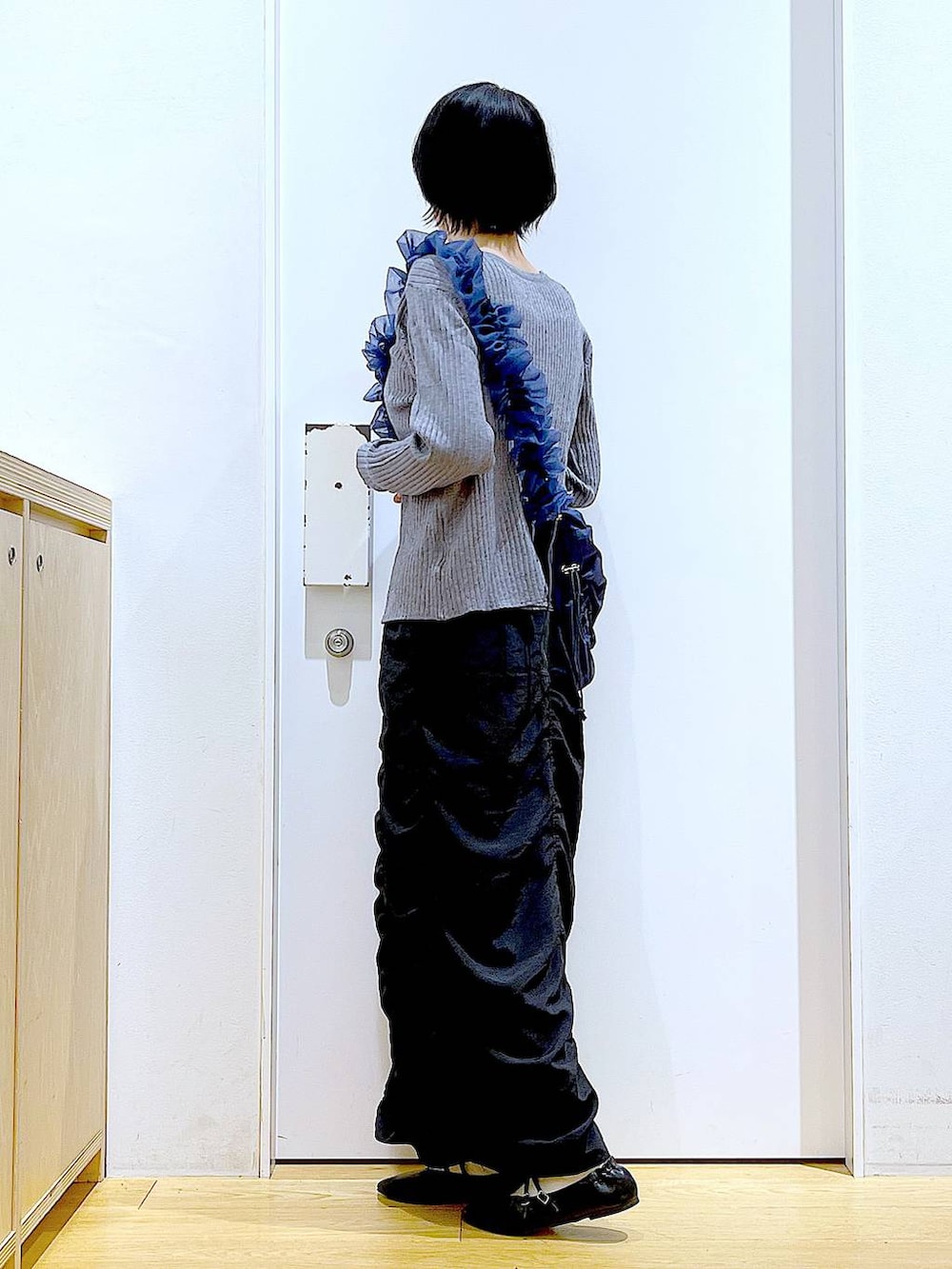 ブラック系のパンプス、ブルー系のショルダーバッグ、グレー系のカーディガン/ボレロを着用したレディースの秋コーディネートの3枚目の写真
