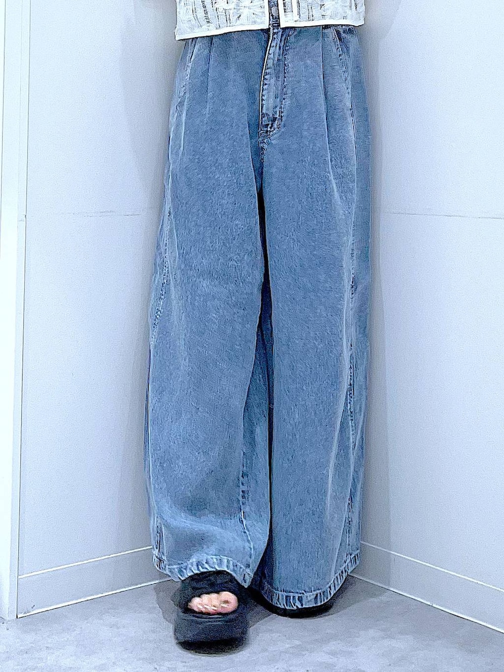 ベージュ系のショルダーバッグ、ブルー系のデニムパンツ、ベージュ系のベストを着用したレディースの夏コーディネートの8枚目の写真