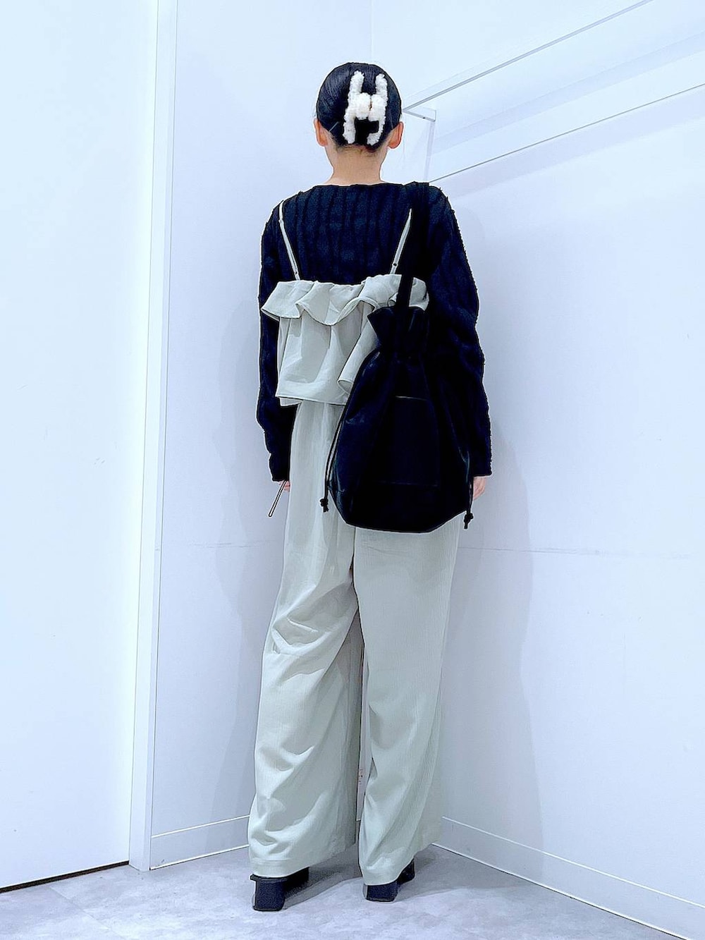 ブラック系のトートバッグ、ブラック系のTシャツ/カットソー、ブラック系のブーツを着用したレディースの春コーディネートの5枚目の写真