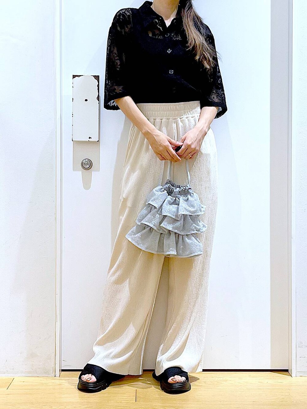 シルバー系のショルダーバッグ、ブラック系のサンダル、ブラック系のシャツ/ブラウスを着用したレディースの夏コーディネートの6枚目の写真