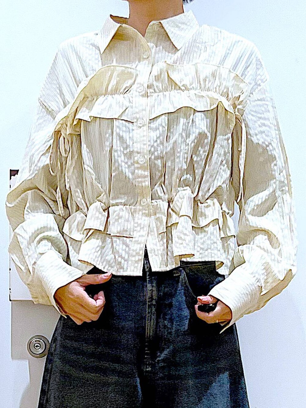 グレー系のショルダーバッグ、ブルー系のデニムパンツ、ホワイト系のスニーカーを着用したレディースの春コーディネートの6枚目の写真