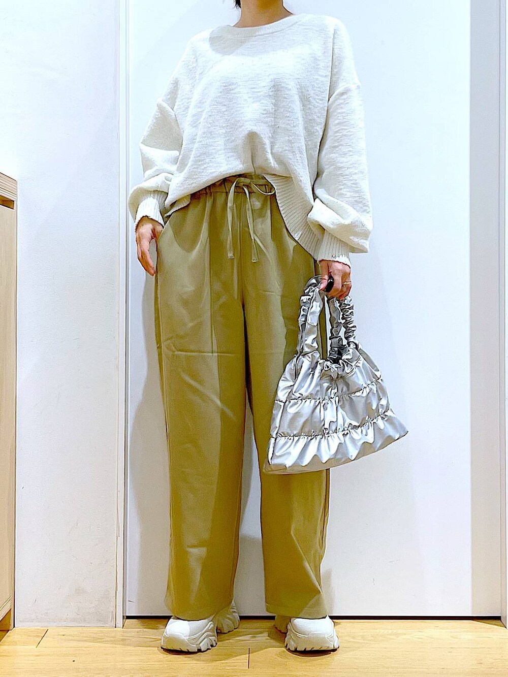 ベージュ系のブーツ、イエロー系のその他パンツ、シルバー系のショルダーバッグを着用したレディースの冬コーディネートの6枚目の写真