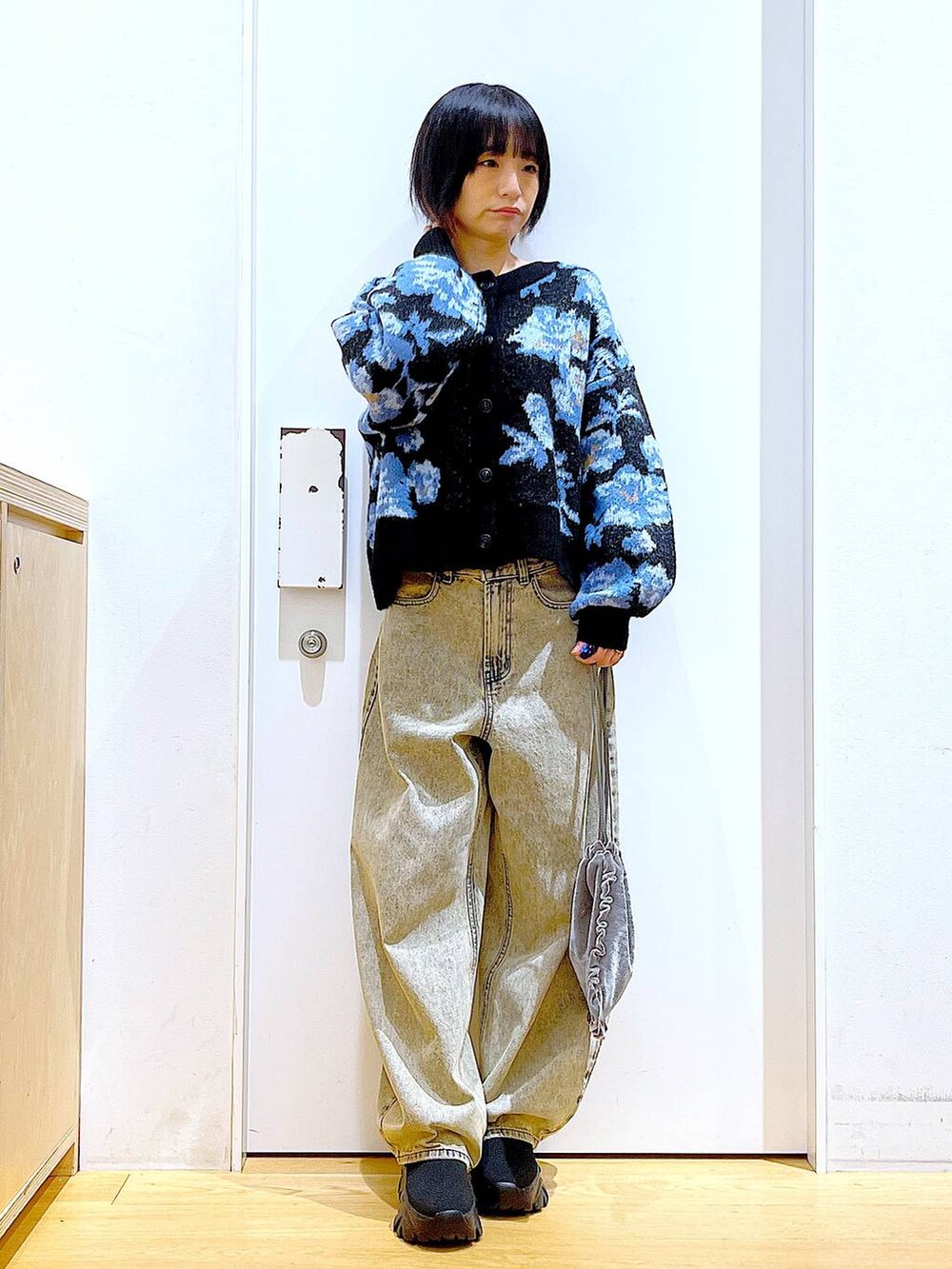 ブラック系のブーツ、グレー系のショルダーバッグ、ベージュ系のデニムパンツを着用したレディースの秋コーディネートの2枚目の写真