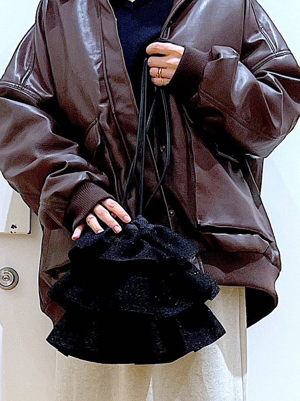 ブラウン系のブルゾン、ブラック系のブーツ、ブラック系のショルダーバッグを着用したレディースの冬コーディネートの9枚目の写真