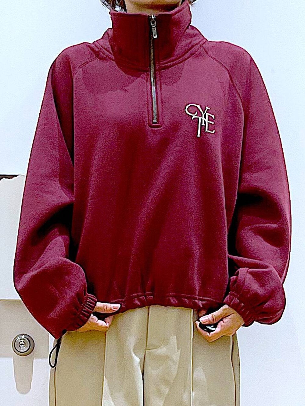 ホワイト系のショルダーバッグ、ブラック系のブーツ、レッド系のスウェットを着用したレディースの冬コーディネートの7枚目の写真