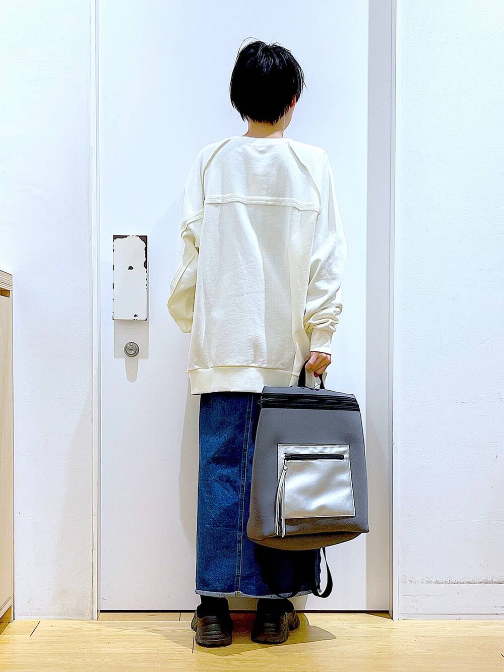 ブルー系のデニムスカート、グレー系のバックパック/リュック、ブラック系のブーツを着用したレディースの冬コーディネートの5枚目の写真