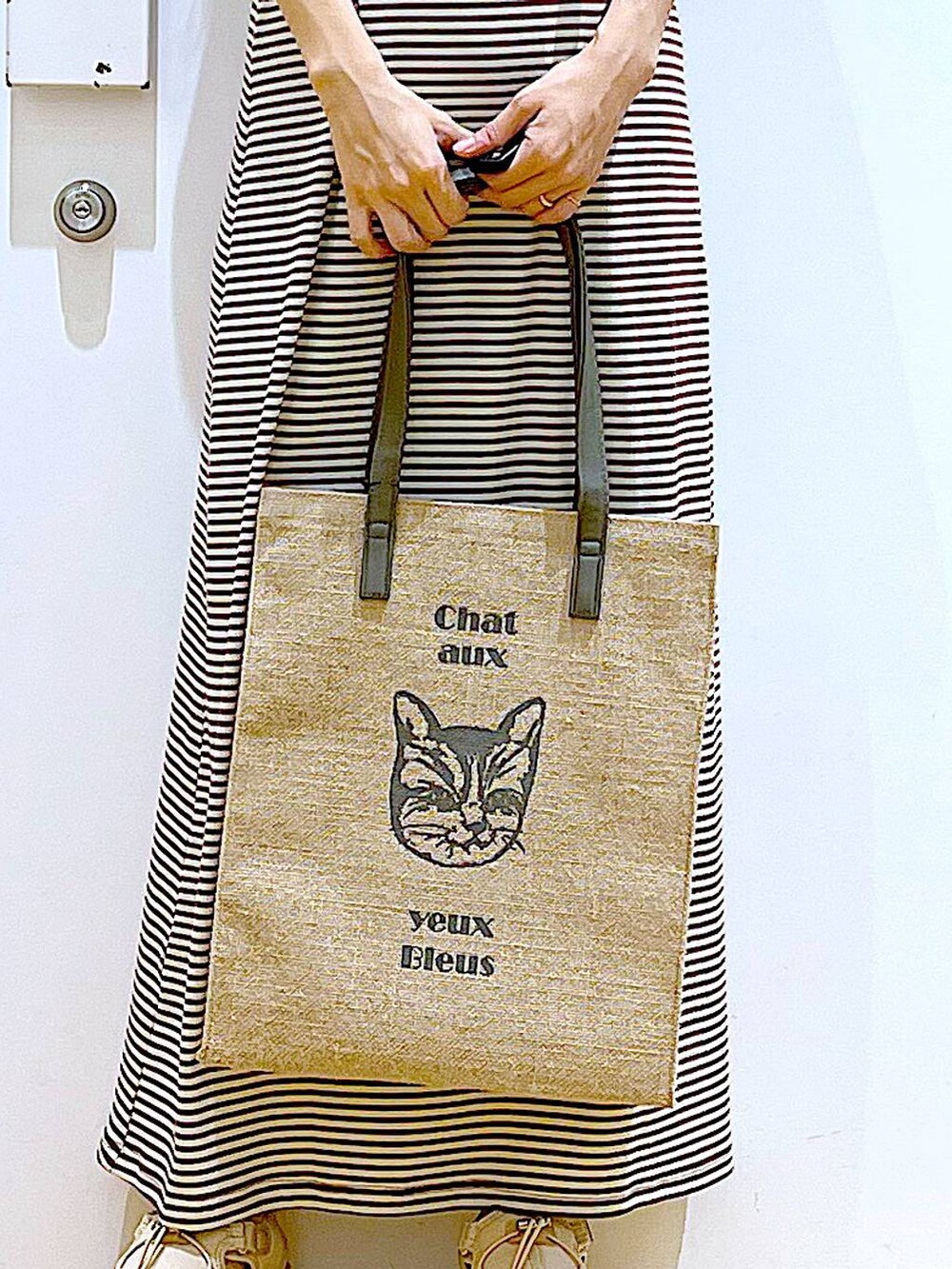 ベージュ系のサンダル、グレー系のトートバッグ、ベージュ系のワンピースを着用したレディースの夏コーディネートの9枚目の写真