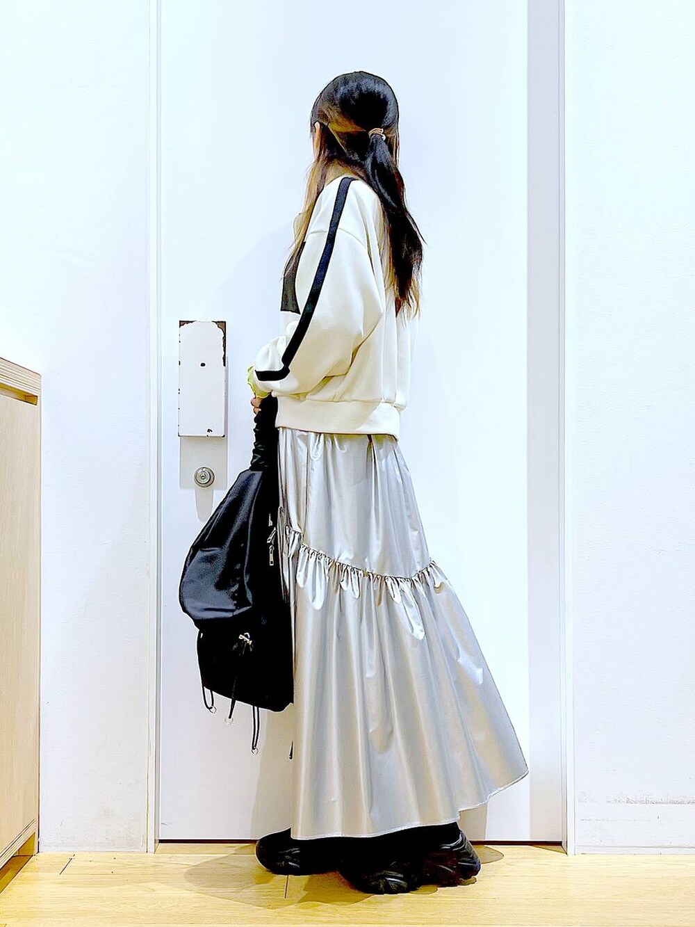 グリーン系のTシャツ/カットソー、ベージュ系のブルゾン、ブラック系のスニーカーを着用したレディースの春コーディネートの3枚目の写真