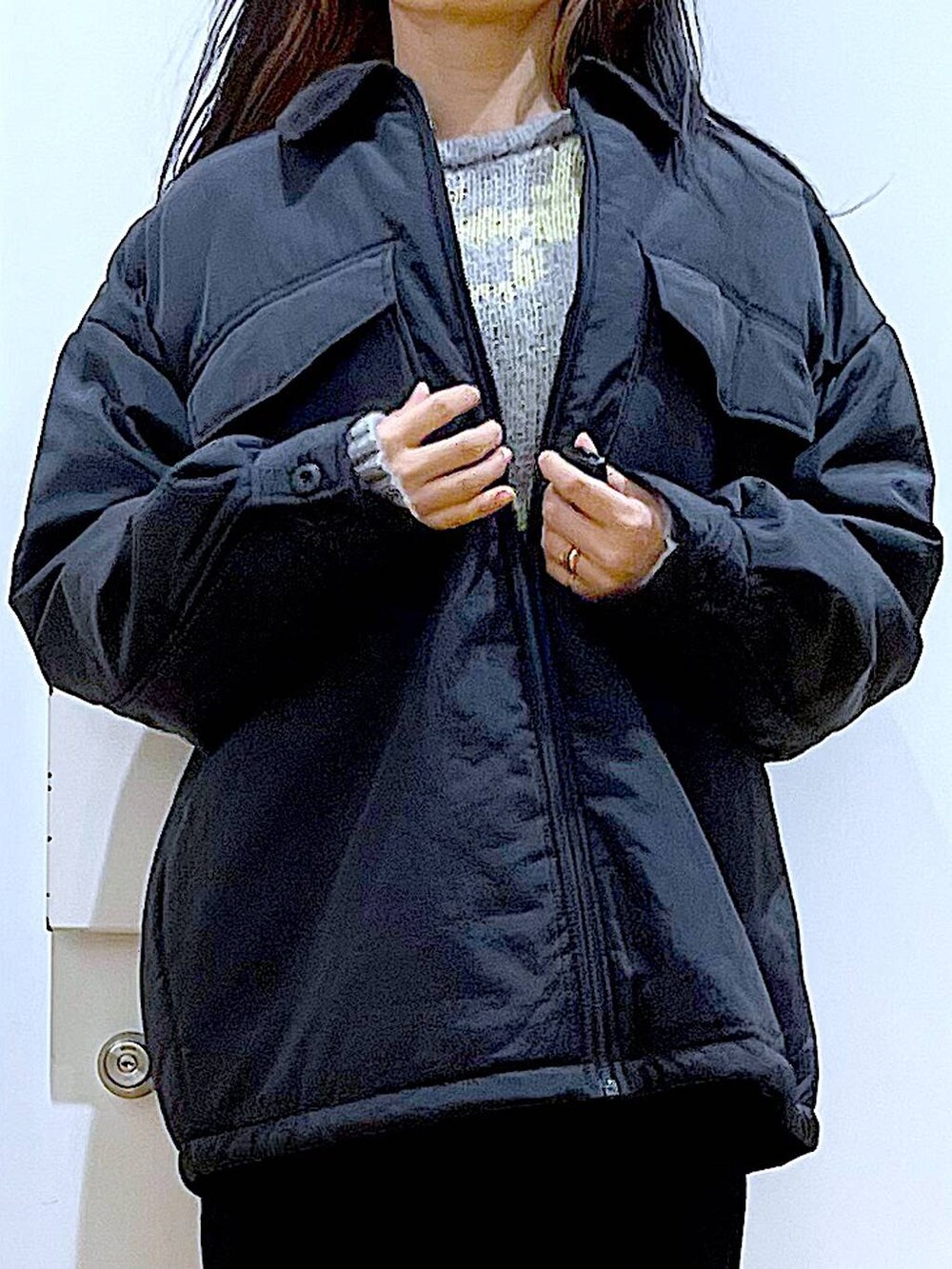 ブラック系のブルゾン、ブラック系のショルダーバッグ、ブラック系のブーツを着用したレディースの冬コーディネートの7枚目の写真