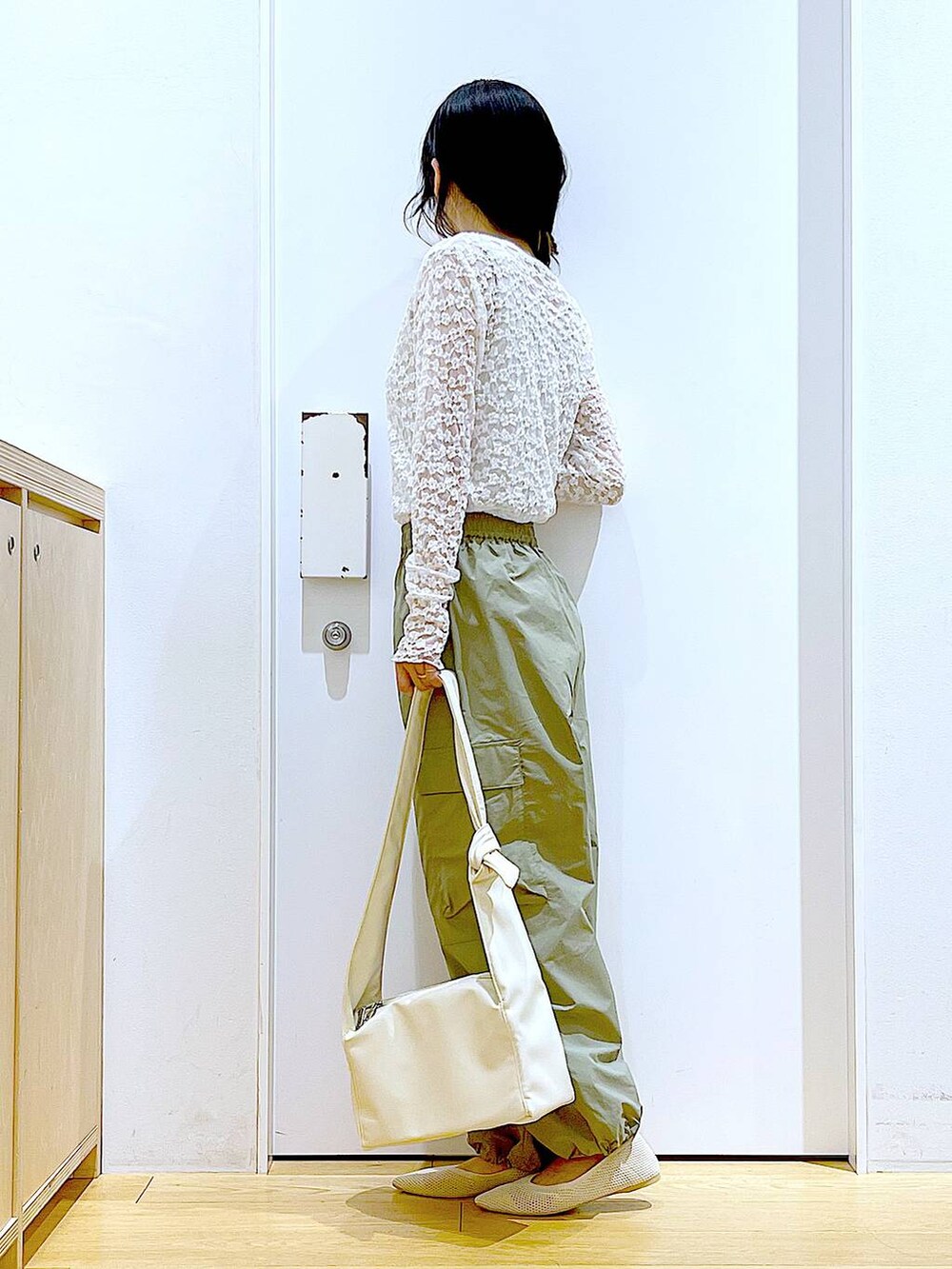 グリーン系のカーゴパンツ、ホワイト系のショルダーバッグ、ホワイト系のパンプスを着用したレディースの春コーディネートの3枚目の写真