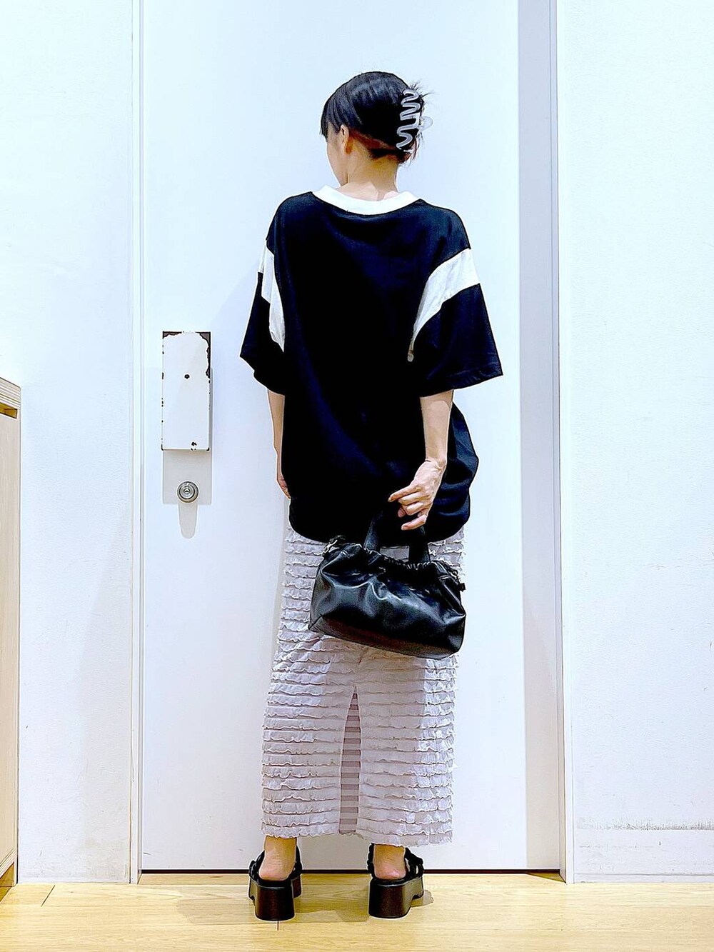 ブラック系のサンダル、ブラック系のショルダーバッグ、ブラック系のTシャツ/カットソーを着用したレディースの夏コーディネートの5枚目の写真