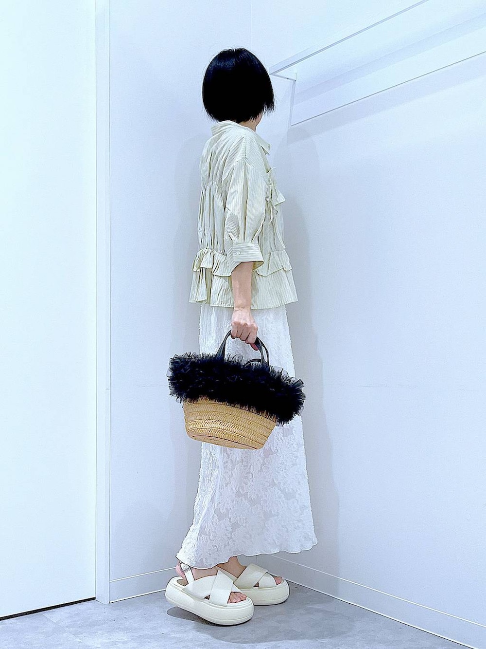 ベージュ系のショルダーバッグ、ホワイト系のサンダル、ホワイト系のスカートを着用したレディースの夏コーディネートの4枚目の写真