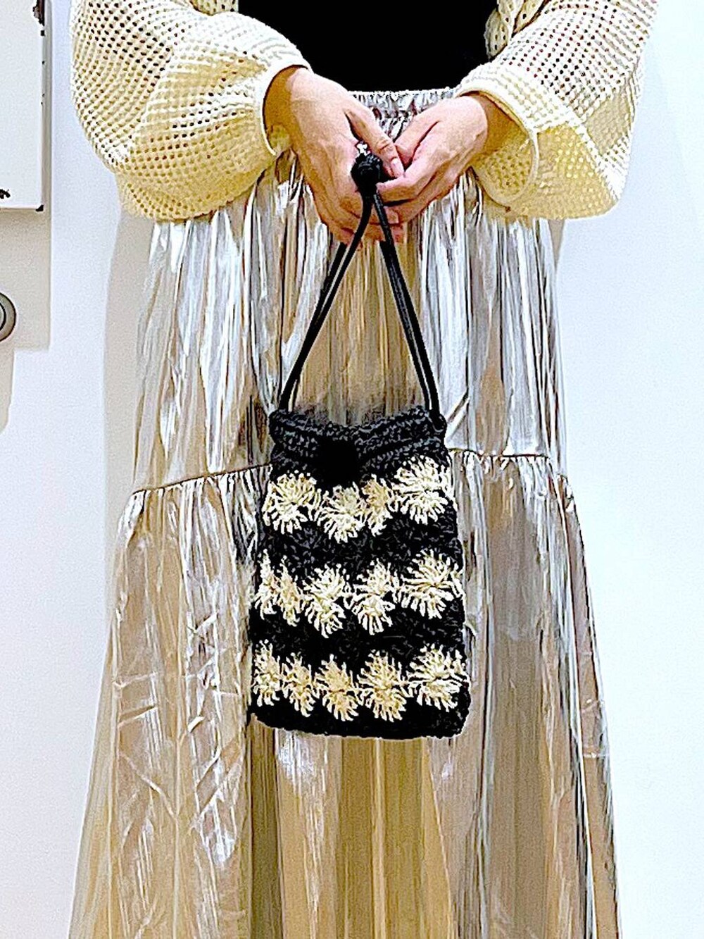 ホワイト系のカーディガン/ボレロ、ブラック系のパンプス、ブラック系のショルダーバッグを着用したレディースの夏コーディネートの9枚目の写真