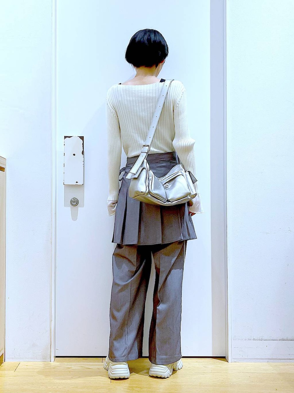 ホワイト系のニット/セーター、グレー系のスラックス、グレー系のスカートを着用したレディースの秋コーディネートの5枚目の写真