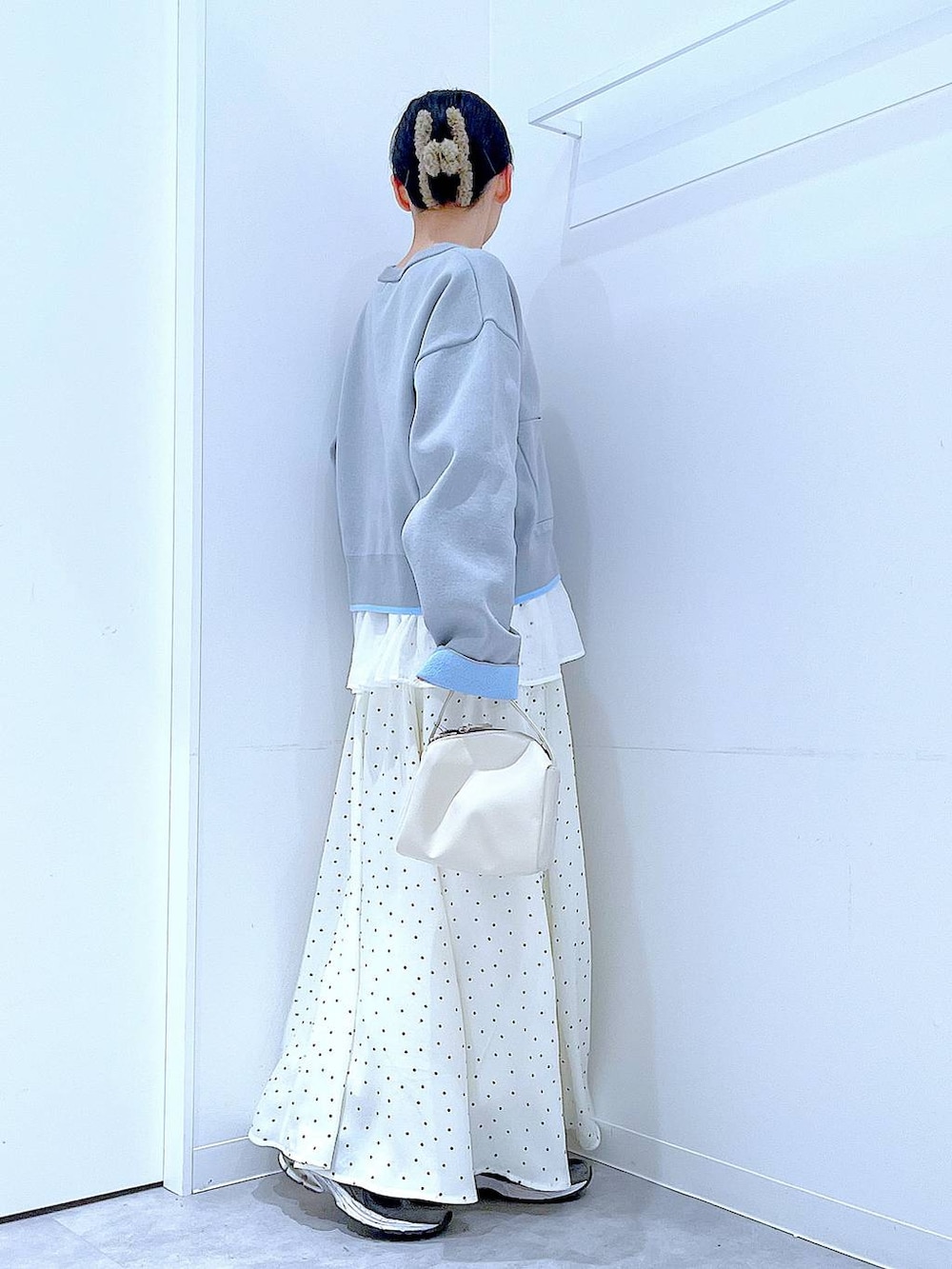 ホワイト系のショルダーバッグ、グレー系のカーディガン/ボレロ、ホワイト系のスカートを着用したレディースの春コーディネートの4枚目の写真