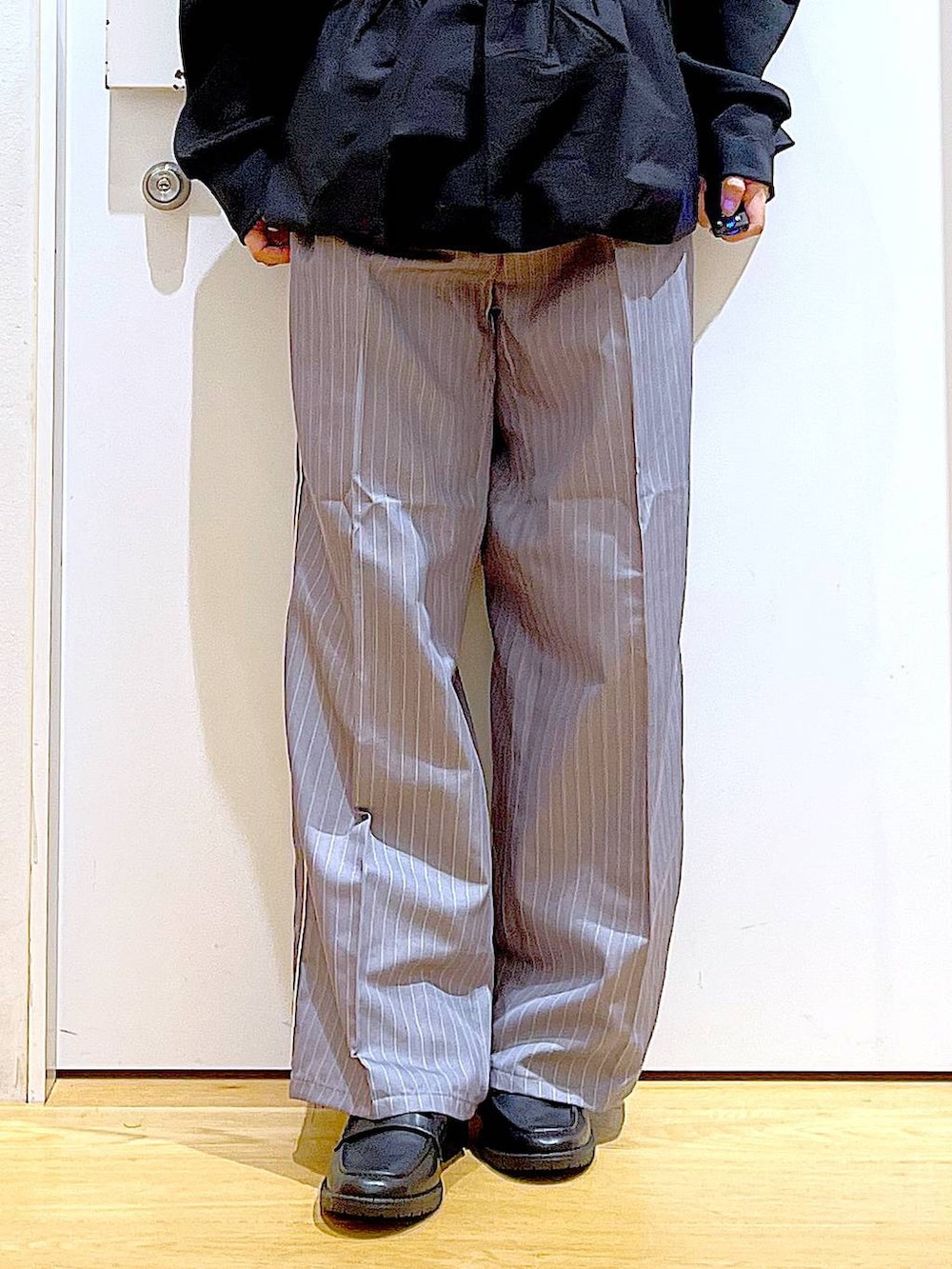 グレー系のスラックス、ブラック系のローファー、その他のショルダーバッグを着用したレディースの秋コーディネートの8枚目の写真