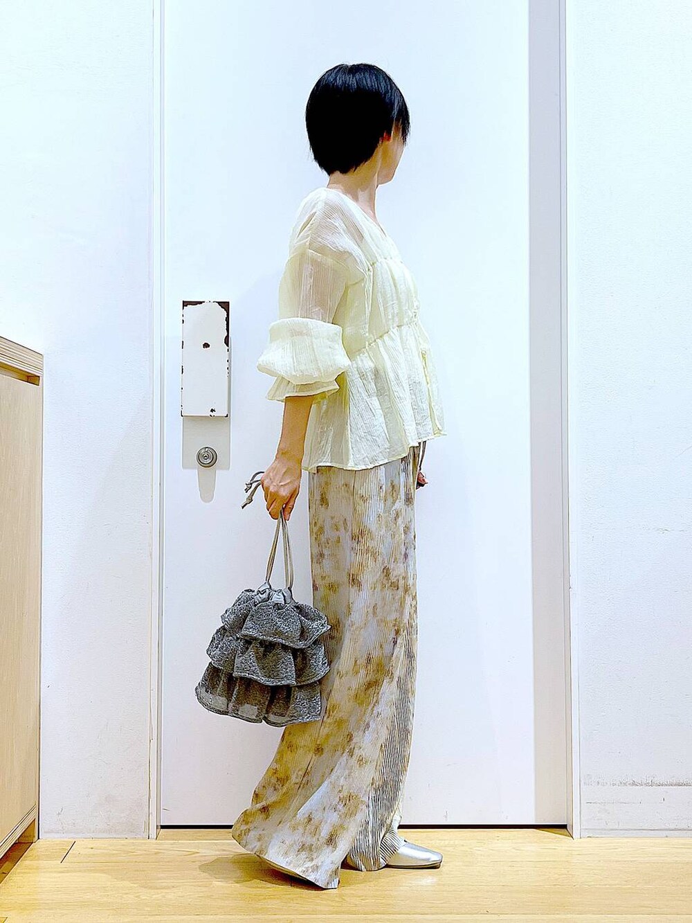 シルバー系のショルダーバッグ、シルバー系のパンプス、ベージュ系のシャツ/ブラウスを着用したレディースの夏コーディネートの4枚目の写真