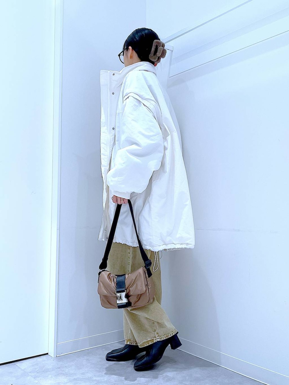 ベージュ系のデニムパンツ、ホワイト系のブルゾン、ブラック系のブーツを着用したレディースの冬コーディネートの3枚目の写真