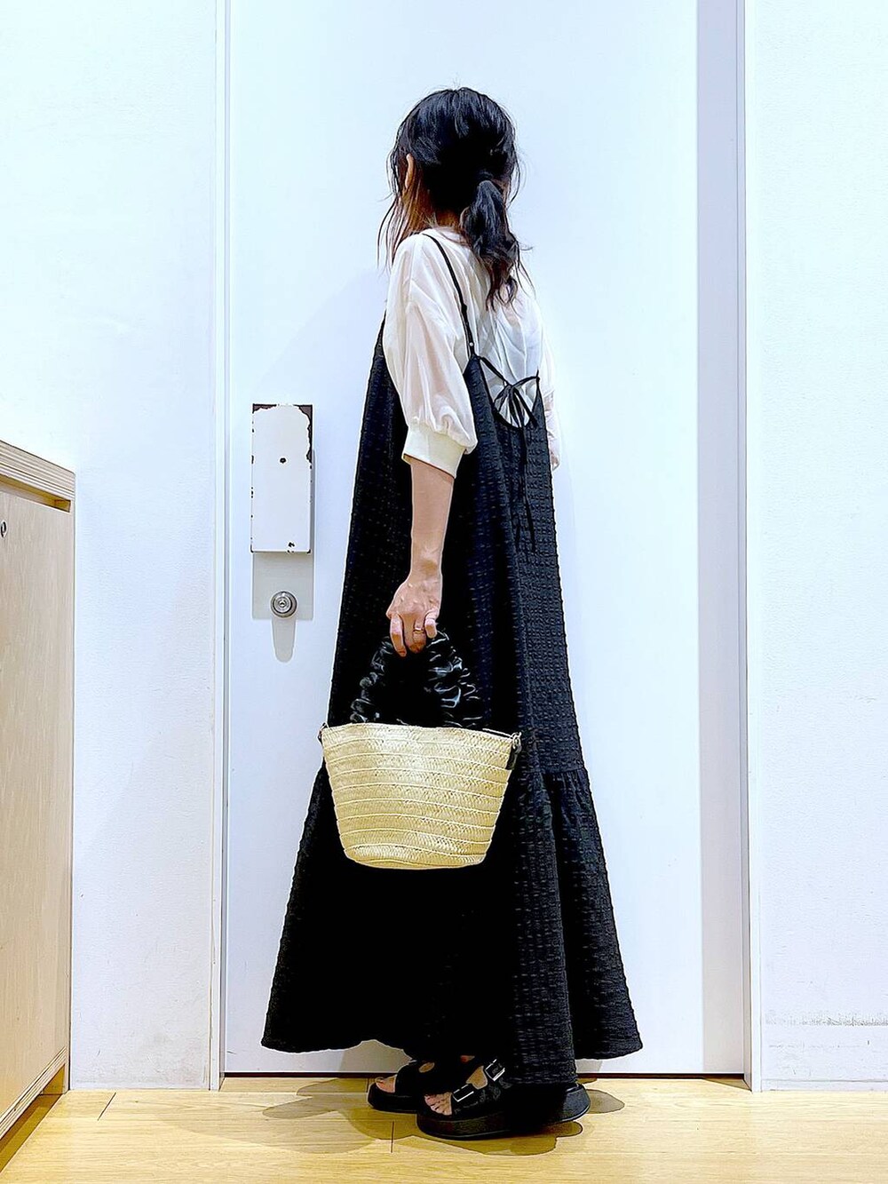 ブラック系のワンピース、ホワイト系のショルダーバッグ、ブラック系のサンダルを着用したレディースの夏コーディネートの3枚目の写真