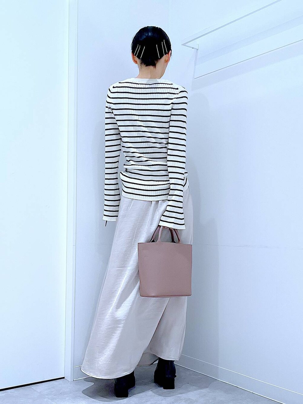 ホワイト系のニット/セーター、ブラウン系のショルダーバッグ、ベージュ系のスカートを着用したレディースの秋コーディネートの5枚目の写真