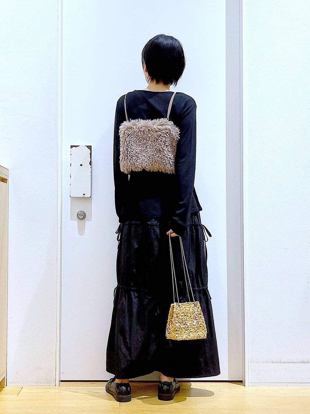 ブラウン系のベスト、ベージュ系のショルダーバッグ、ブラック系のTシャツ/カットソーを着用したレディースの秋コーディネートの5枚目の写真