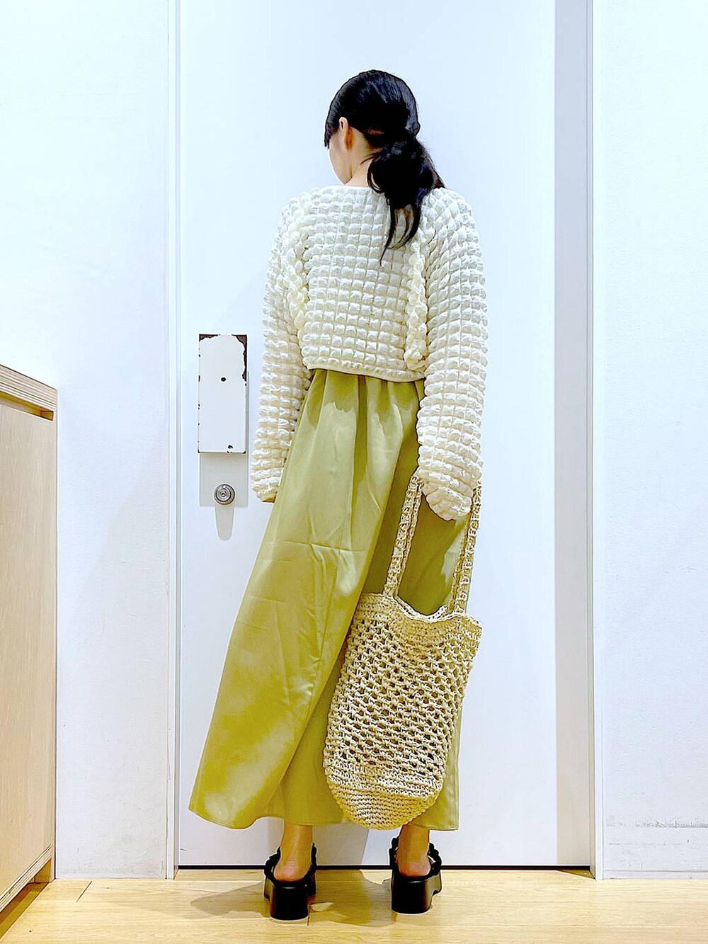 ブラック系のサンダル、ホワイト系のトートバッグ、ベージュ系のカーディガン/ボレロを着用したレディースの夏コーディネートの5枚目の写真