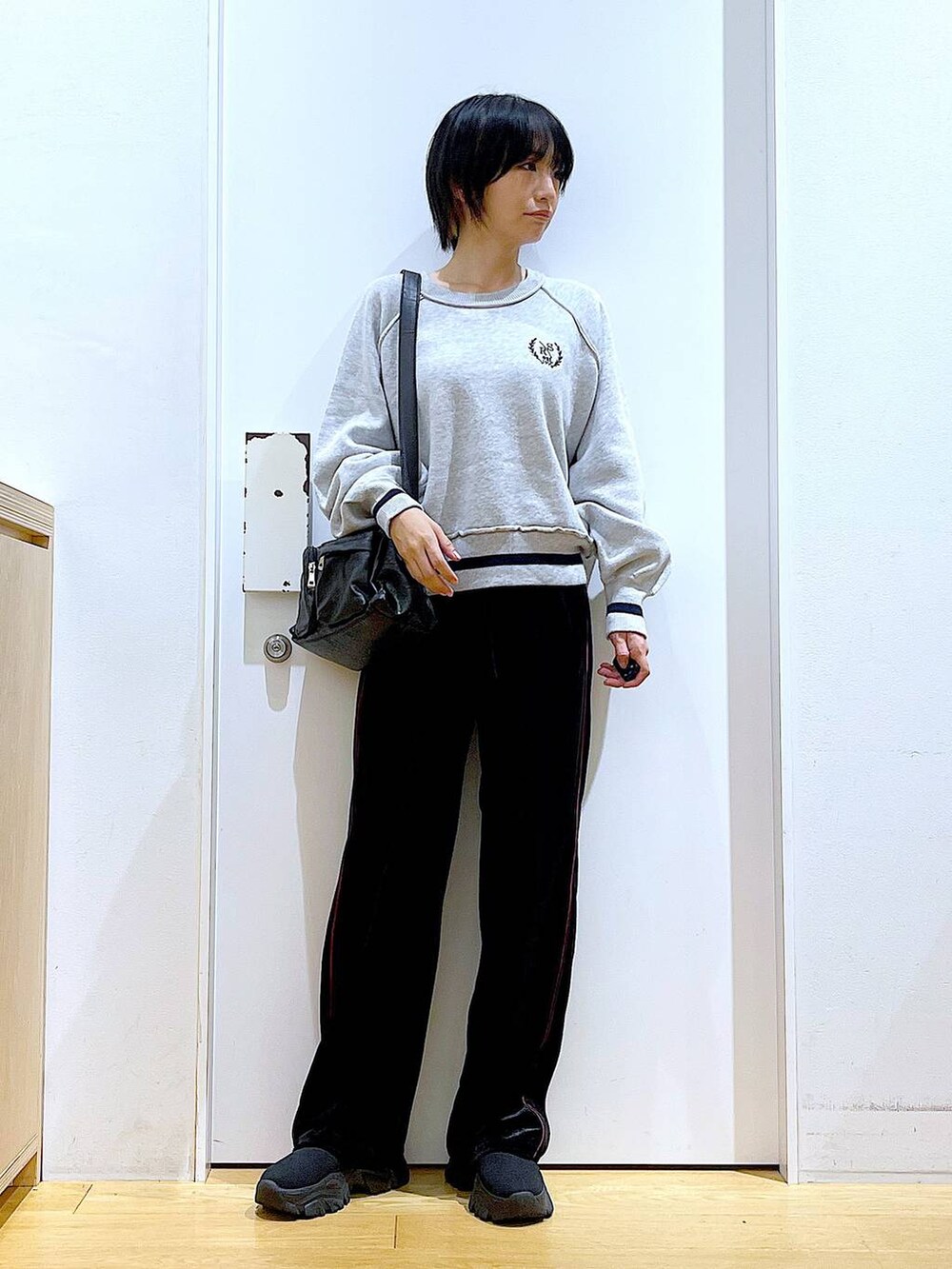 ブラック系のブーツ、ブラック系のその他パンツ、ブラック系のショルダーバッグを着用したレディースの冬コーディネートの2枚目の写真