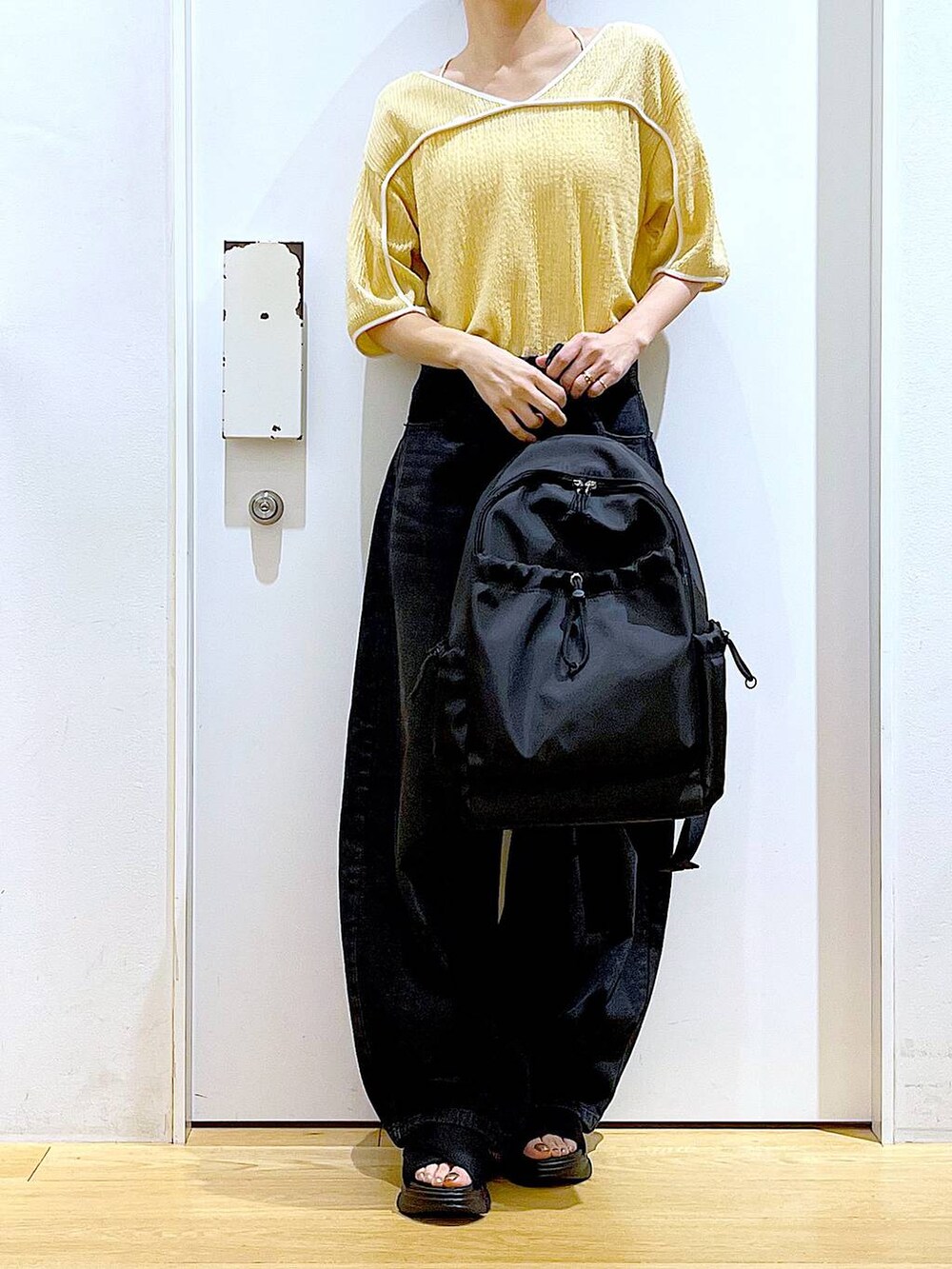 ブラック系のサンダル、ブラック系のバックパック/リュック、ブラック系のデニムパンツを着用したレディースの夏コーディネートの6枚目の写真