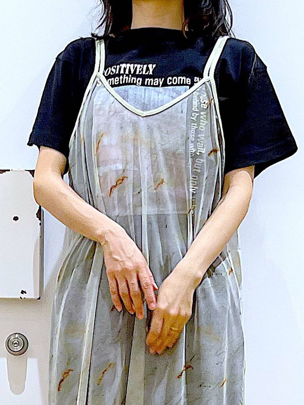 ブラック系のサンダル、ブラック系のトートバッグ、ベージュ系のワンピースを着用したレディースの夏コーディネートの7枚目の写真