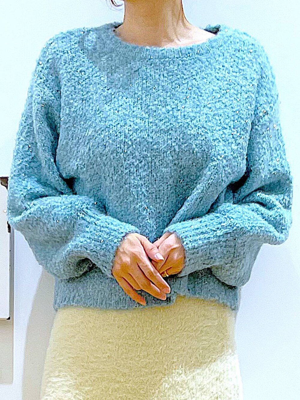 ホワイト系のショルダーバッグ、ベージュ系のブーツ、ホワイト系のスカートを着用したレディースの冬コーディネートの7枚目の写真