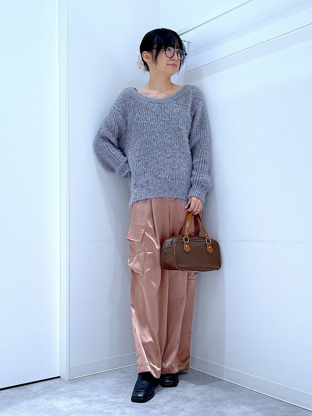 ブラック系のブーツ、ブラウン系のショルダーバッグ、ピンク系のカーゴパンツを着用したレディースの冬コーディネートの2枚目の写真