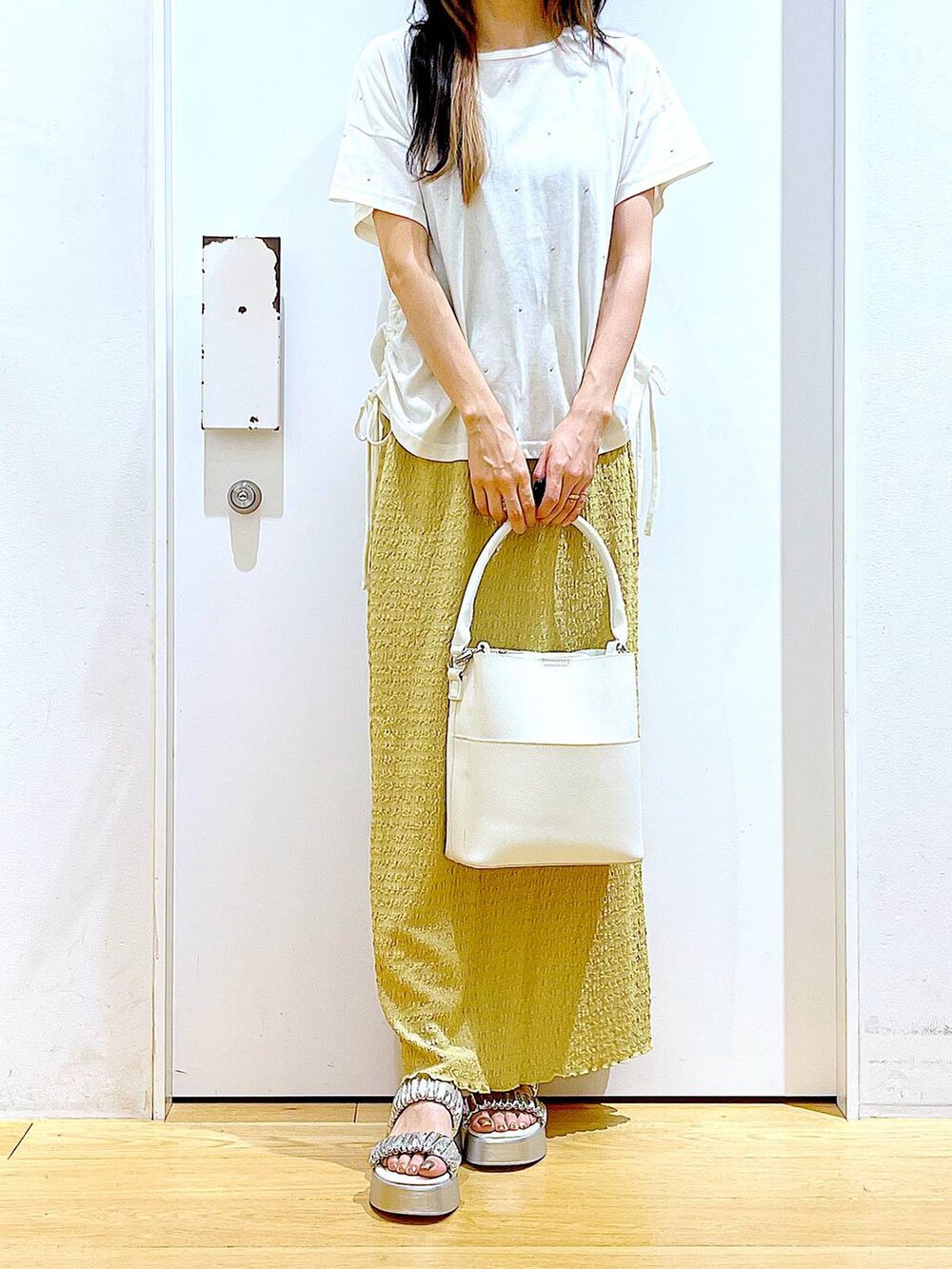 シルバー系のサンダル、ホワイト系のショルダーバッグ、グリーン系のスカートを着用したレディースの夏コーディネートの6枚目の写真
