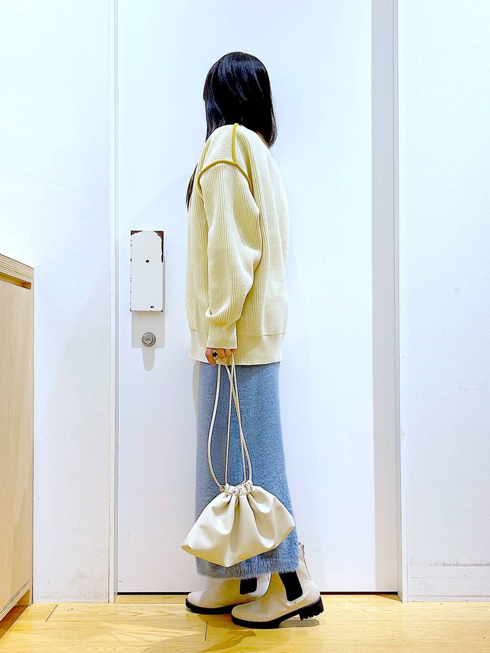 ベージュ系のブーツ、ベージュ系のニット/セーター、ベージュ系のショルダーバッグを着用したレディースの冬コーディネートの3枚目の写真