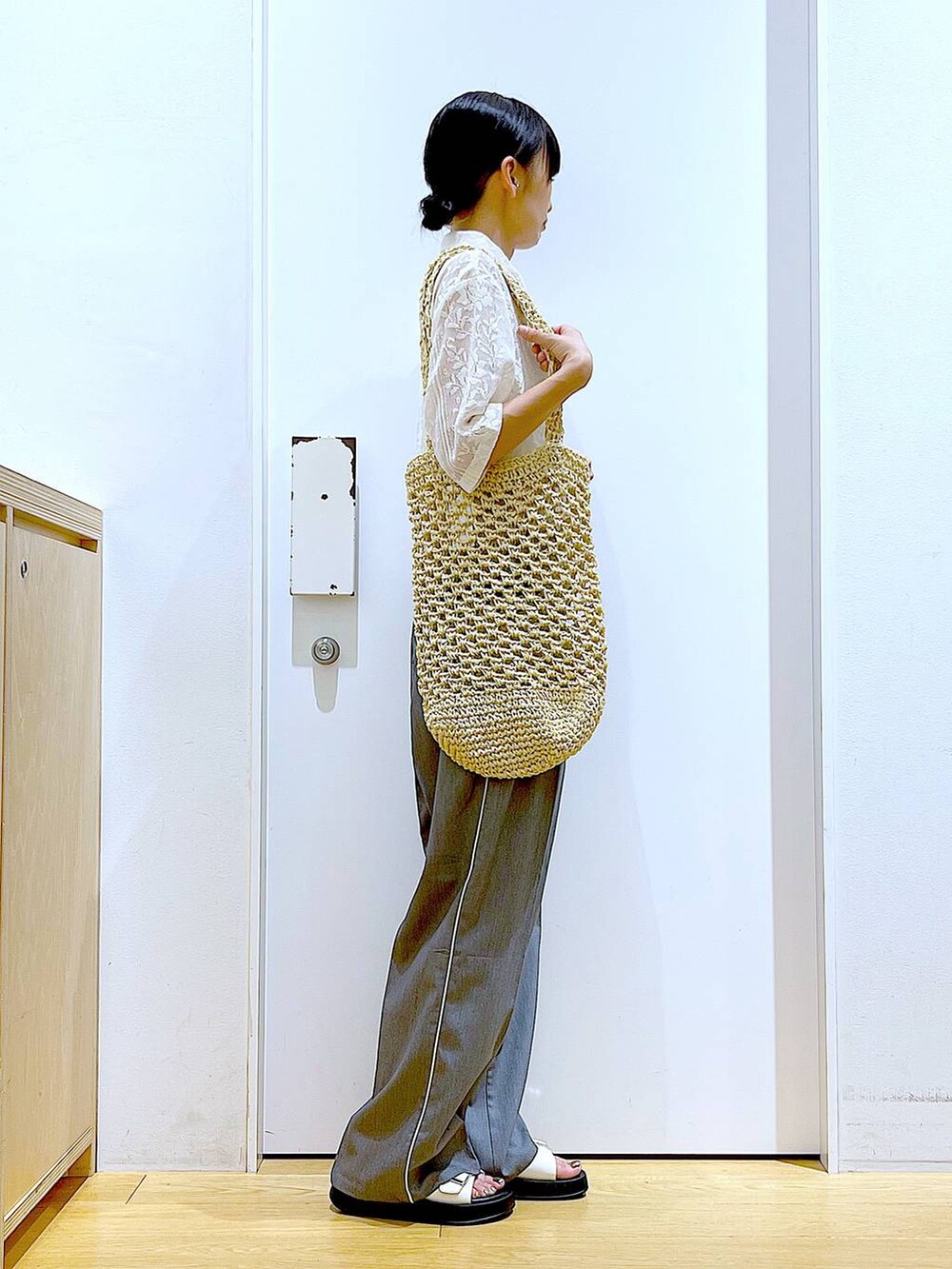 ホワイト系のサンダル、ホワイト系のトートバッグ、ベージュ系のシャツ/ブラウスを着用したレディースの秋コーディネートの4枚目の写真