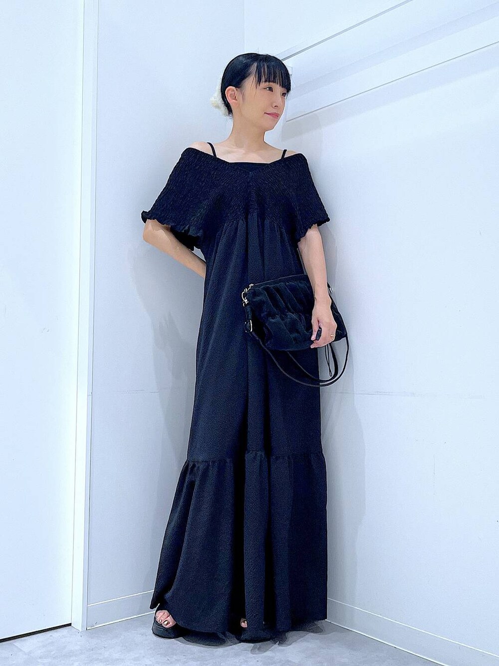 ブラック系のワンピース、ブラック系のショルダーバッグ、ホワイト系のバレッタ/ヘアクリップを着用したレディースの夏コーディネートの2枚目の写真